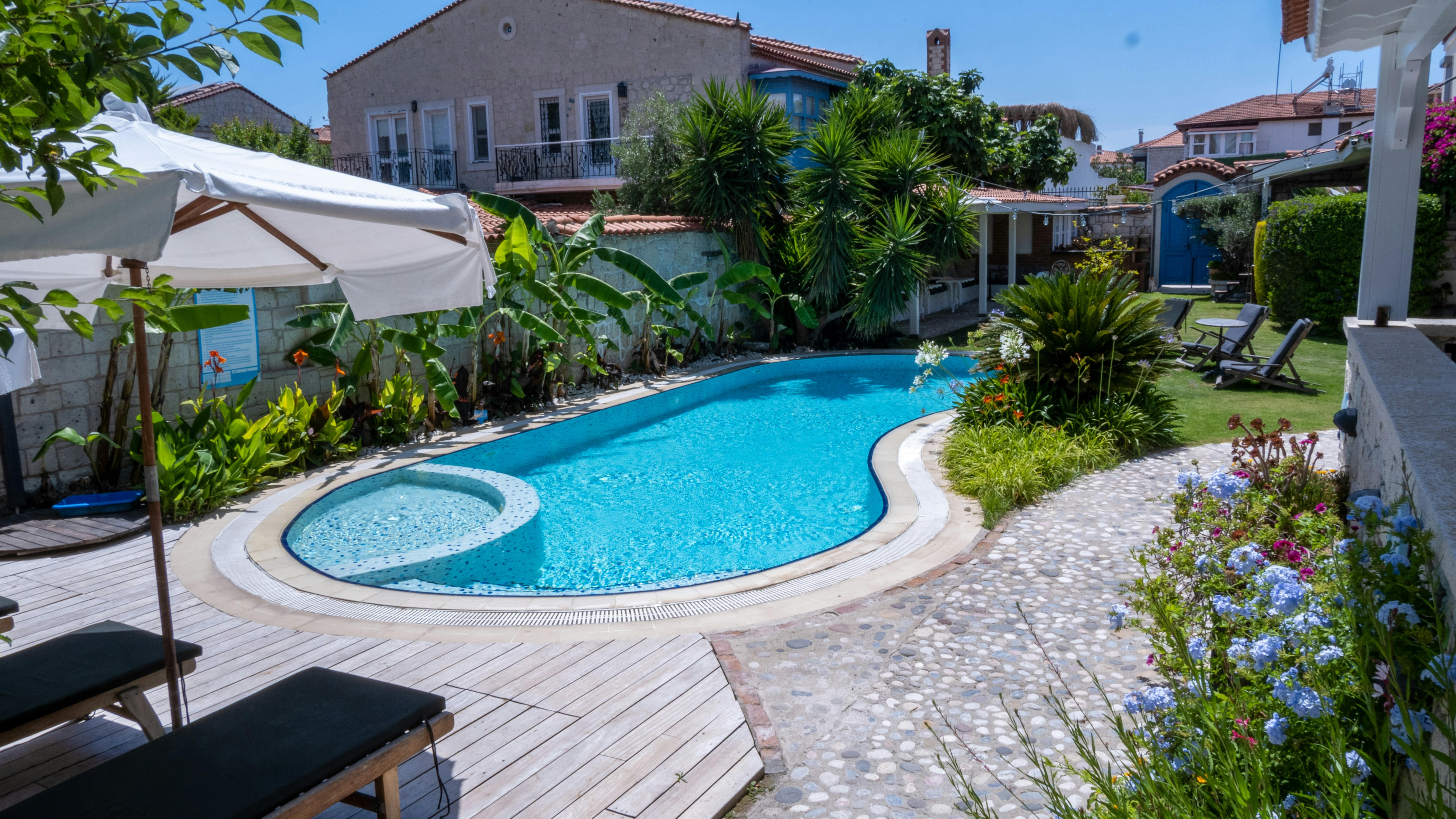 a backyard with a swimming pool surrounded by greenery, Butik otelde büyük bir havuz. Big pool in boutique hotel.