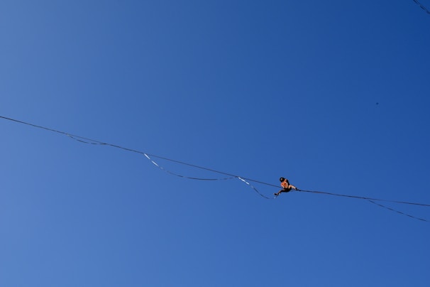 Young student balancing on a tightrope with focused determination inside the circus school gym.