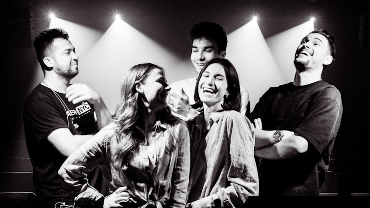 A diverse persone in un ambiente luminoso, sorridenti mentre condividono momenti di crescita e supporto reciproco.