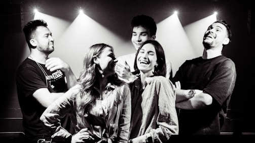 A group of friends posing together inside a photobooth, laughing and enjoying.