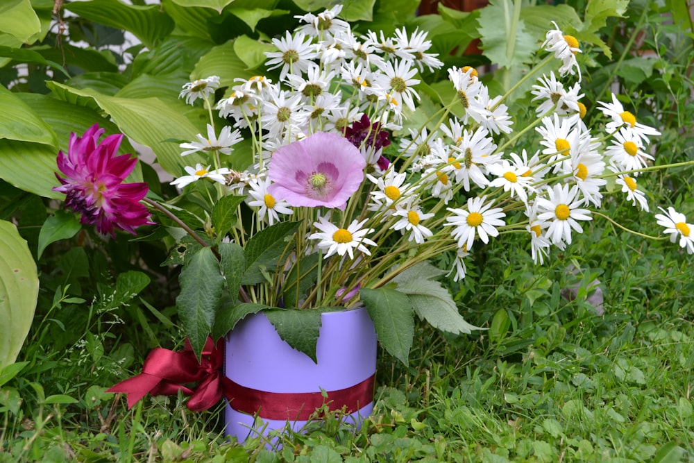 a blue vase filled with white and purple flowers