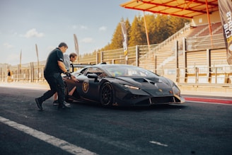 An influencer shaking hands with a car brand representative beside a sleek sports car.