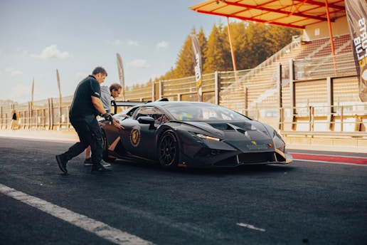 An influencer shaking hands with a car brand representative beside a sleek sports car.