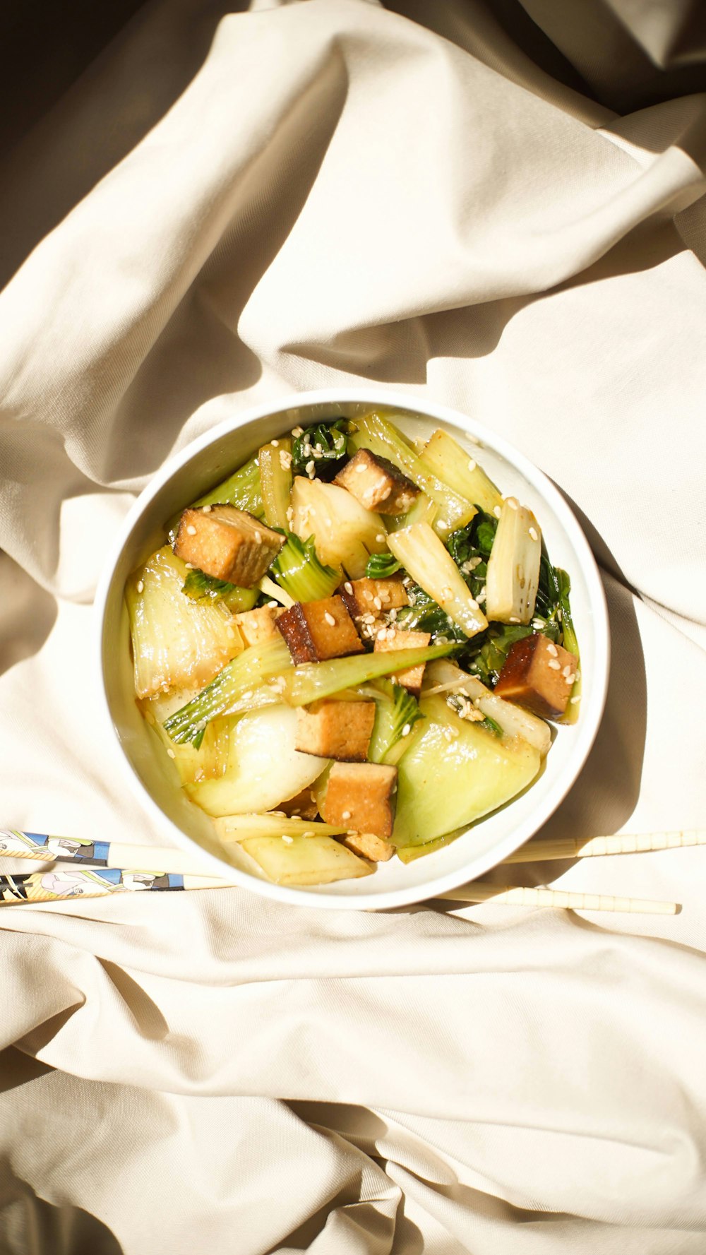 a white bowl filled with food on top of a bed