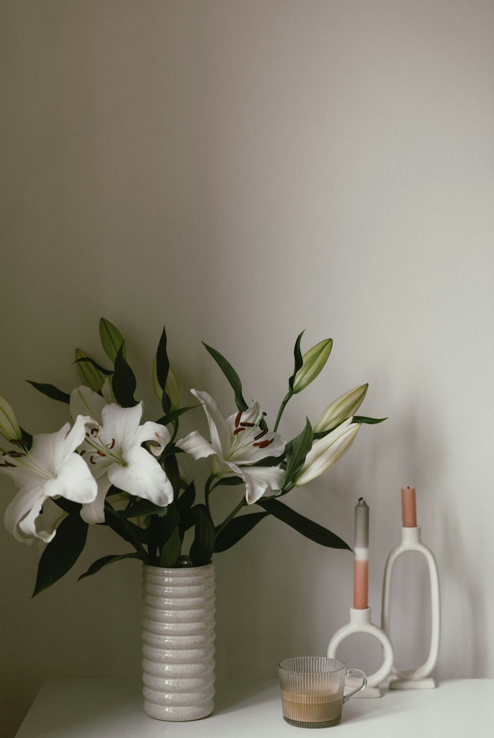 a vase with flowers and a candle on a table