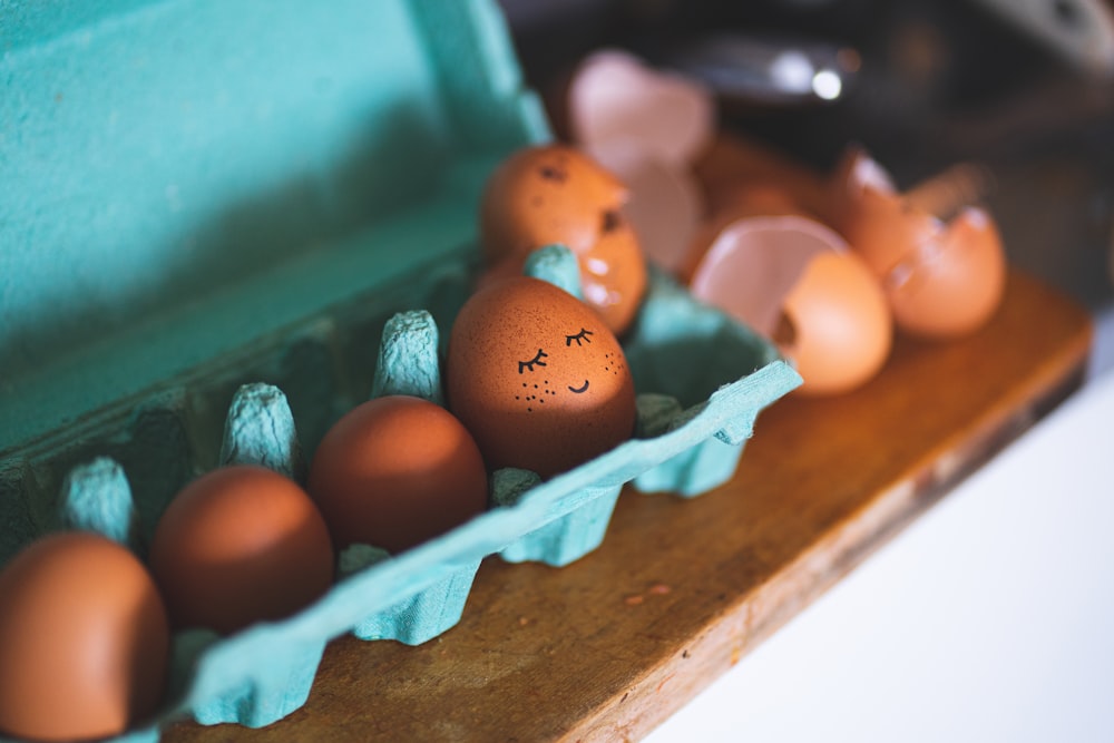 a carton of eggs with faces drawn on them