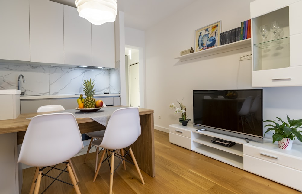 a kitchen with a table and chairs and a television