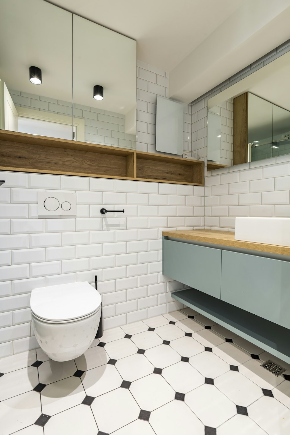 a bathroom with a toilet, sink, and mirror