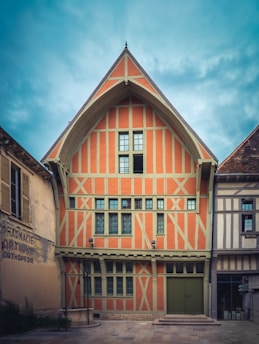a large orange and white building with a clock on it's side