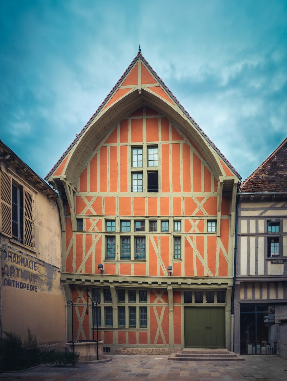 a large orange and white building with a clock on it's side