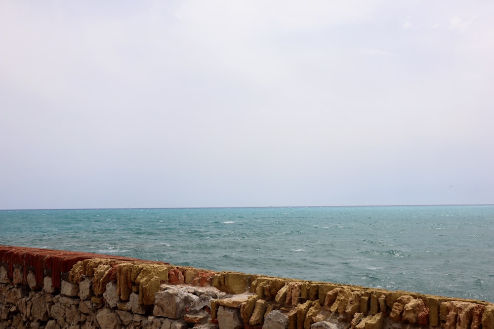 a large body of water sitting next to a stone wall