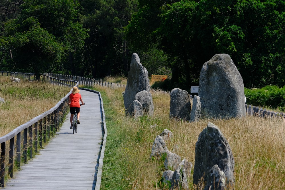 a woman riding a bike down a wooden path