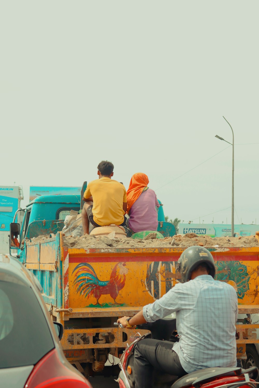 a couple of men riding on the back of a truck