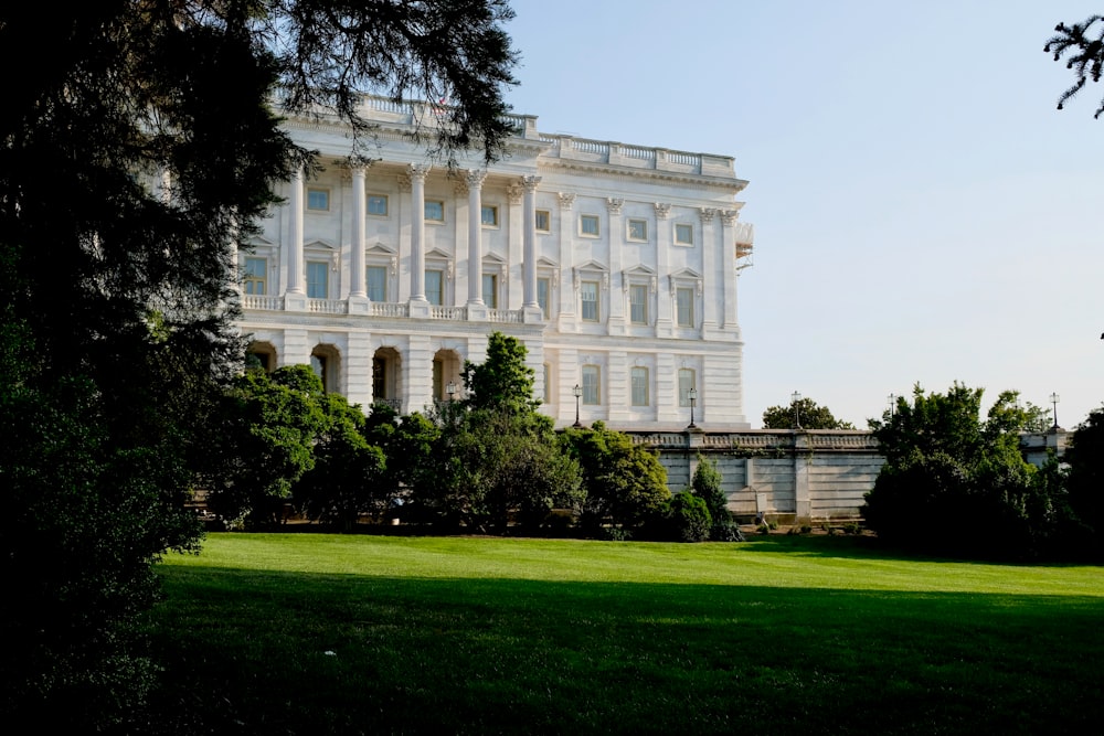 a large white building with trees in front of it