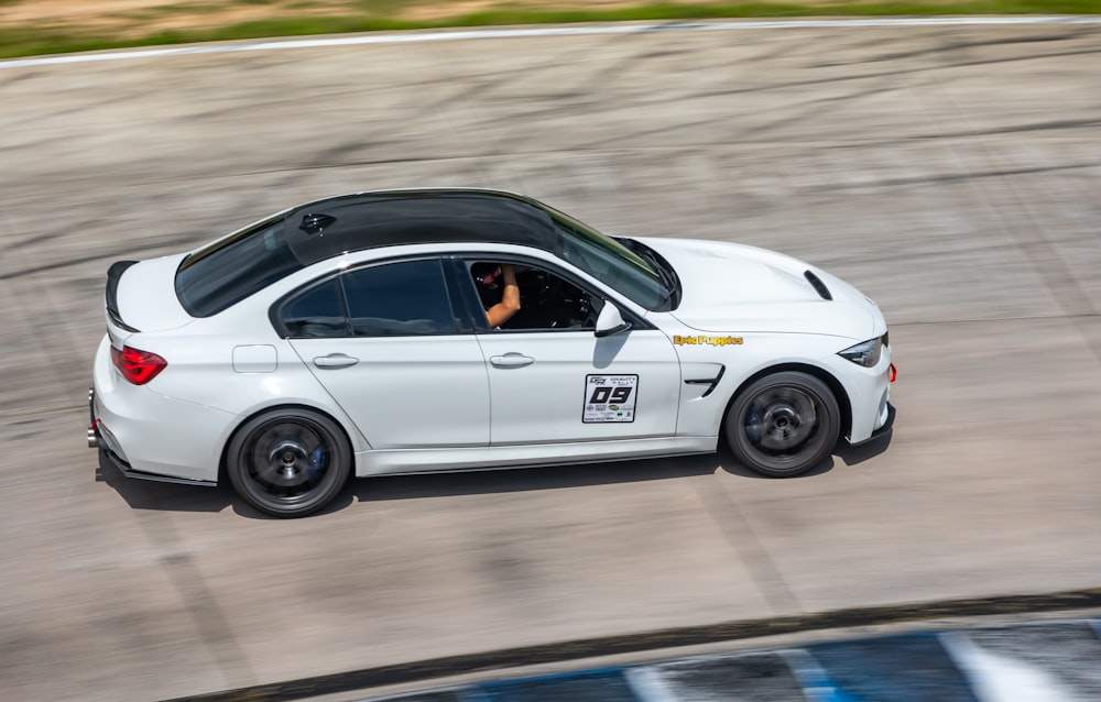 a white car driving down a race track