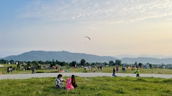 a group of people standing on top of a lush green field