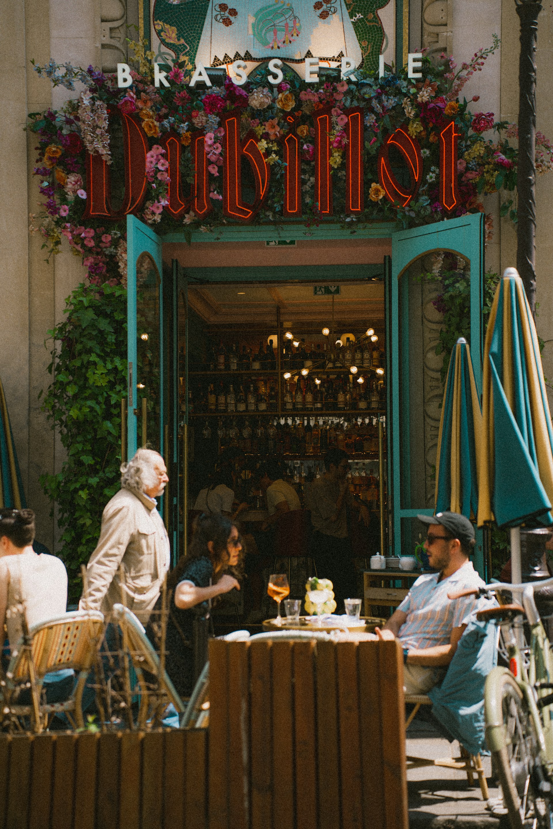 Evening scene at Brasserie de Drie Esschen with friends sharing drinks and laughter in a relaxed, inviting atmosphere.