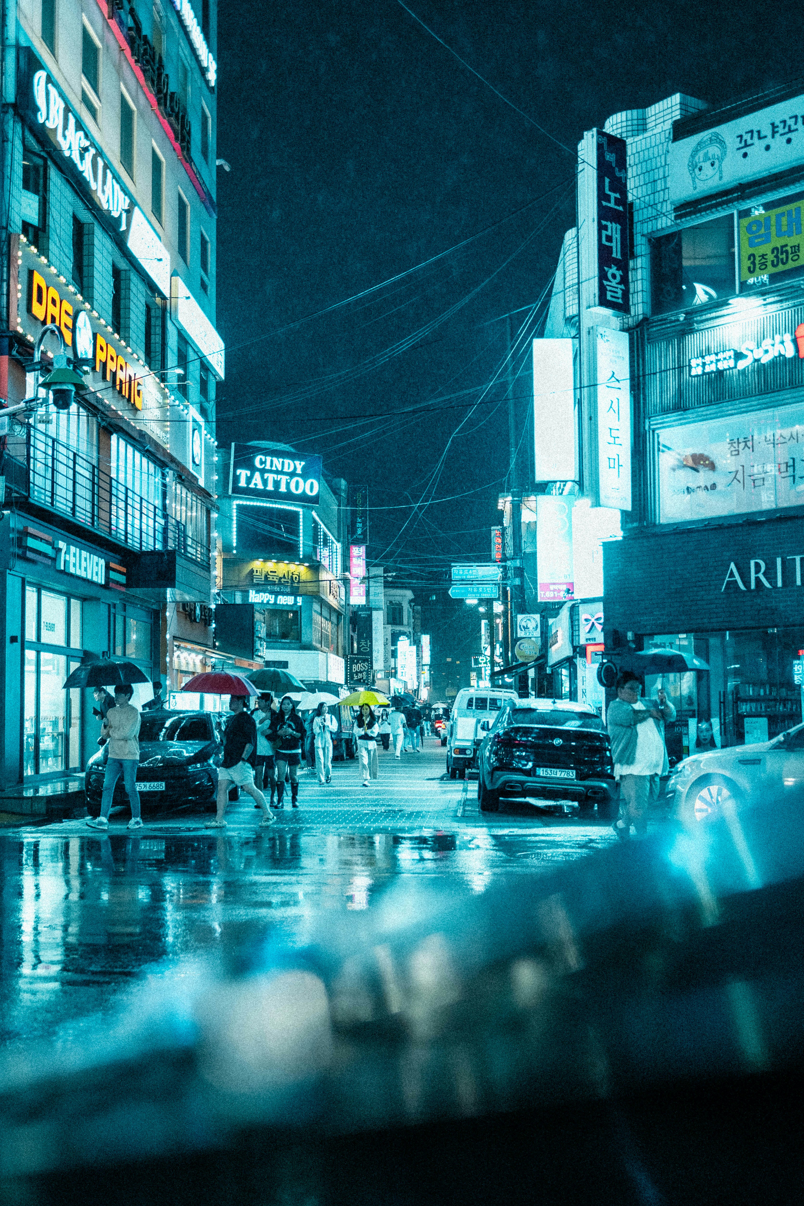 a city street at night with cars and people