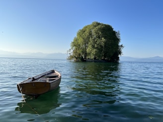 A small wooden boat navigating through calm Caribbean waters surrounded by lush islands.