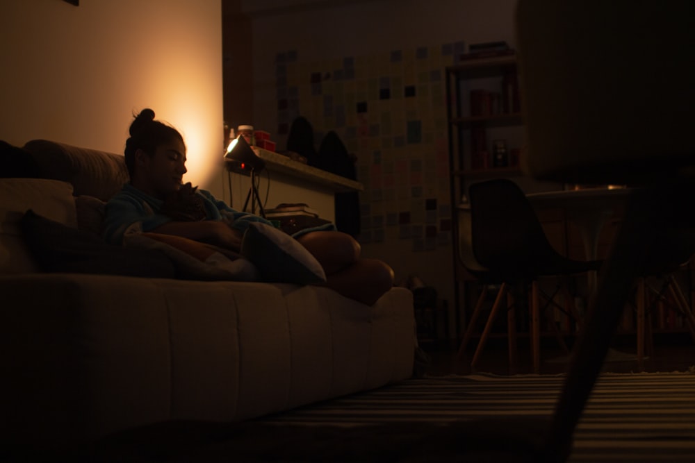 a person sitting on a couch in a dark room