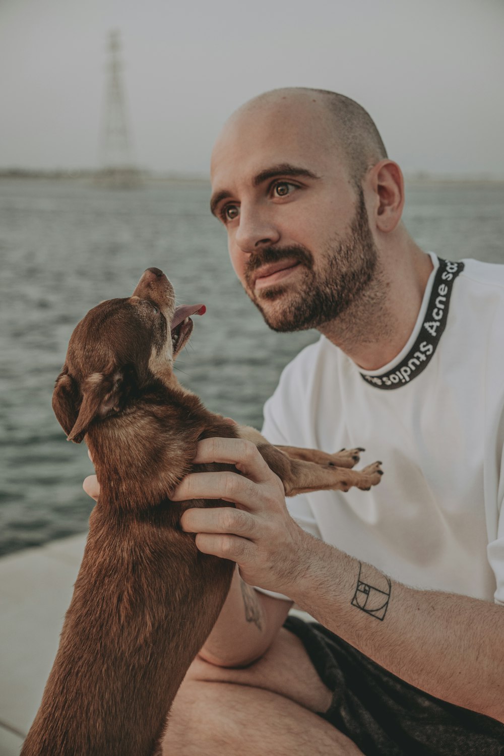 a man sitting on a boat holding a dog