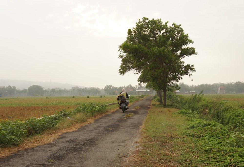 a person riding a motorcycle down a dirt road