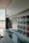 A modern interior with a sleek, glossy cabinet and a display of colorful samples on the wall. The setting is well-lit with natural light coming through a large window, and the decor is minimalistic and polished.