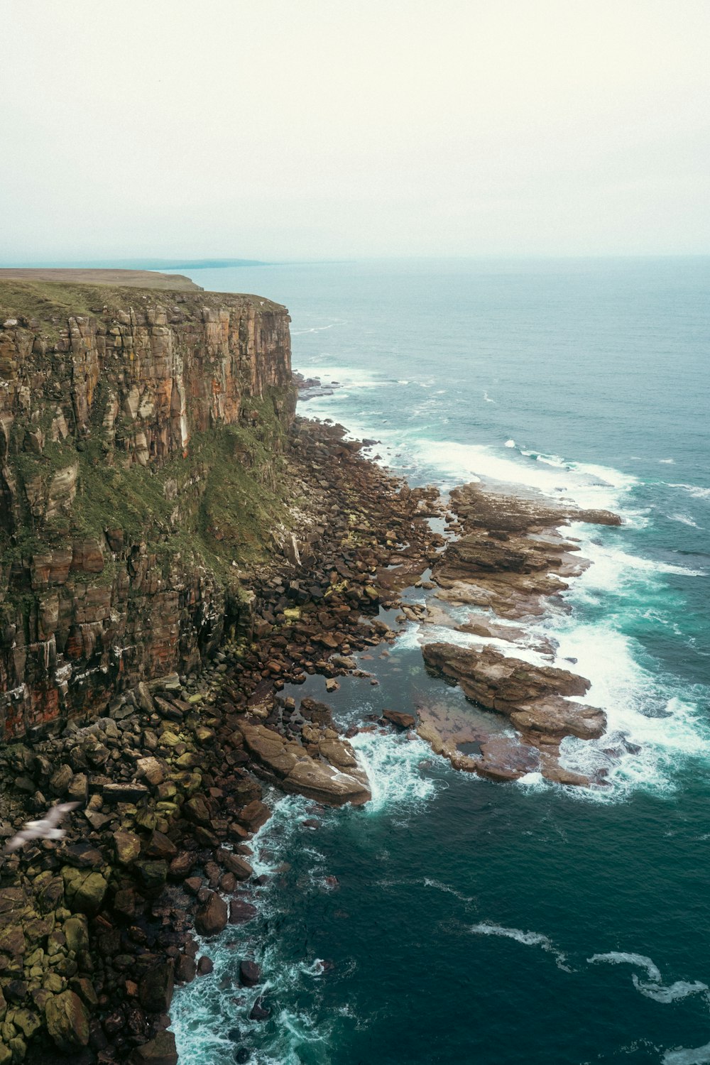 a rocky cliff overlooks a body of water