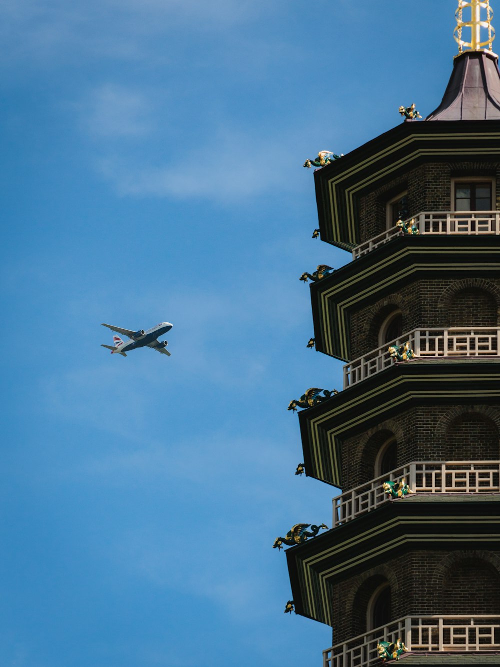 Un aereo sta sorvolando un'alta torre