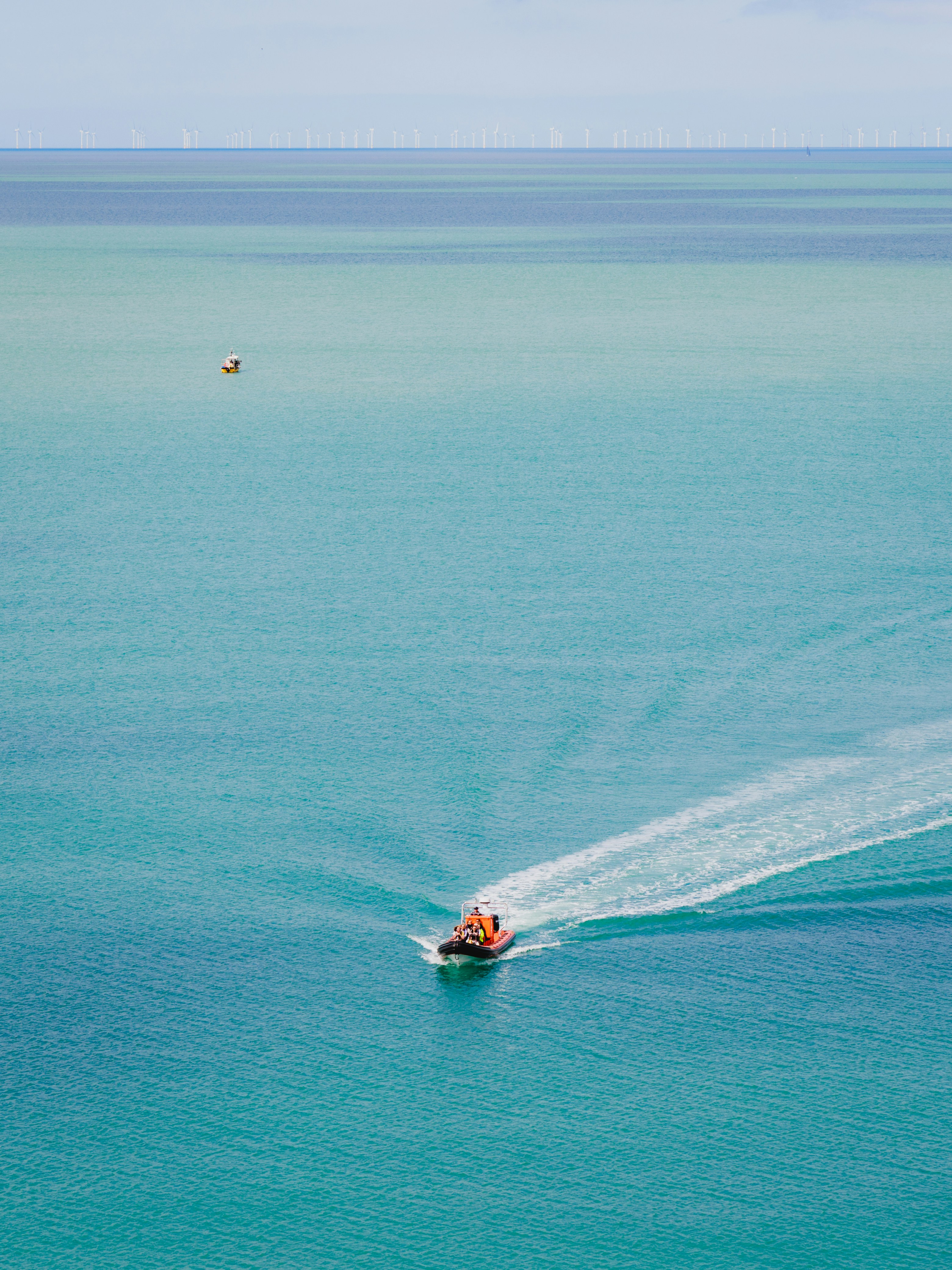A small boat in the middle of a large body of water photo – Free Seven ...