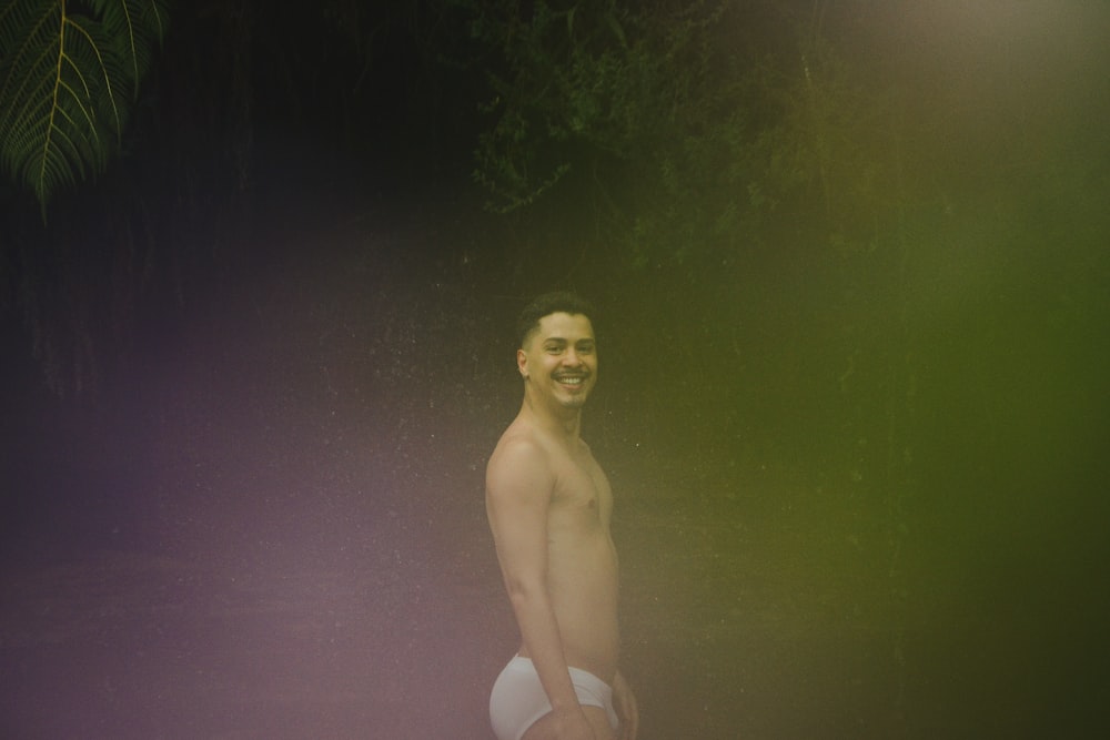 a man in a white underwear standing in the dark