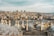 A panoramic view of a cityscape featuring a series of domed rooftops in the foreground, a river with boats in the middle, and a dense array of historic and modern buildings on a hill in the background. The Galata Tower is prominently visible, surrounded by various skyscrapers.