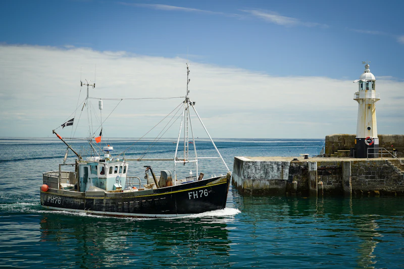 Bateau de pêche entrant dans un port au lever du jour