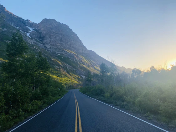 A serene view of Georgian mountains at sunrise with a winding road inviting travelers.