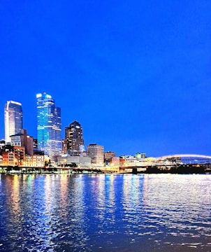 A sleek city skyline at dusk with illuminated buildings reflecting ambition and growth.