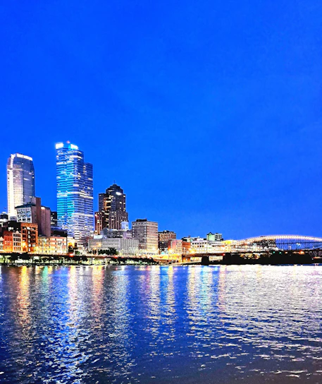 A dynamic city skyline at dusk with illuminated bridges symbolizing connection and progress.