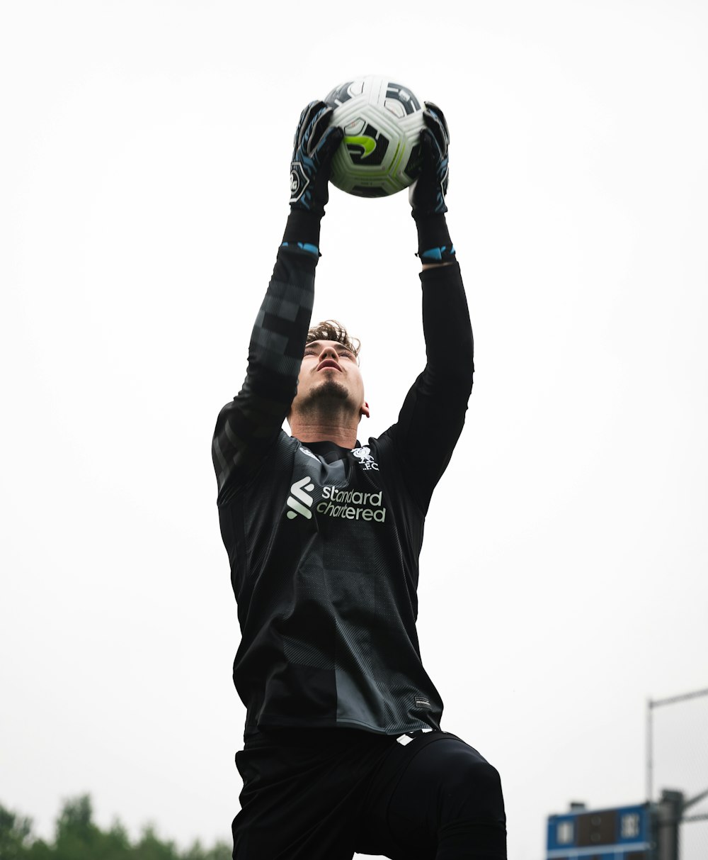Foto Um homem se aproximando para pegar uma bola de futebol