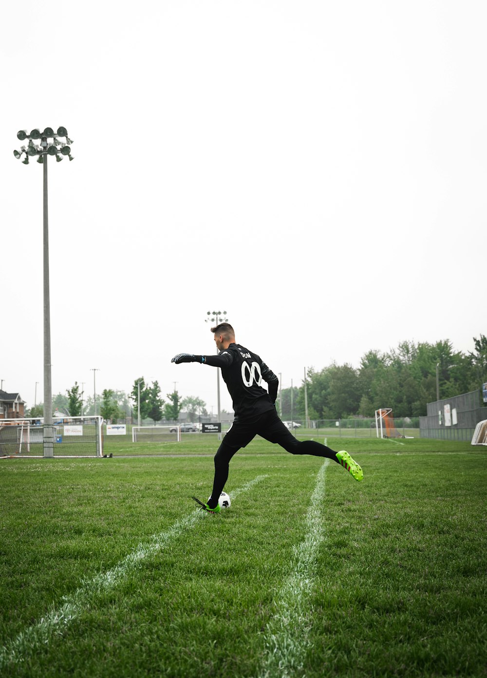 a man in a black uniform kicking a soccer ball