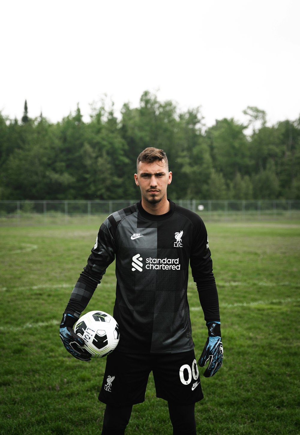 a man holding a soccer ball in a field