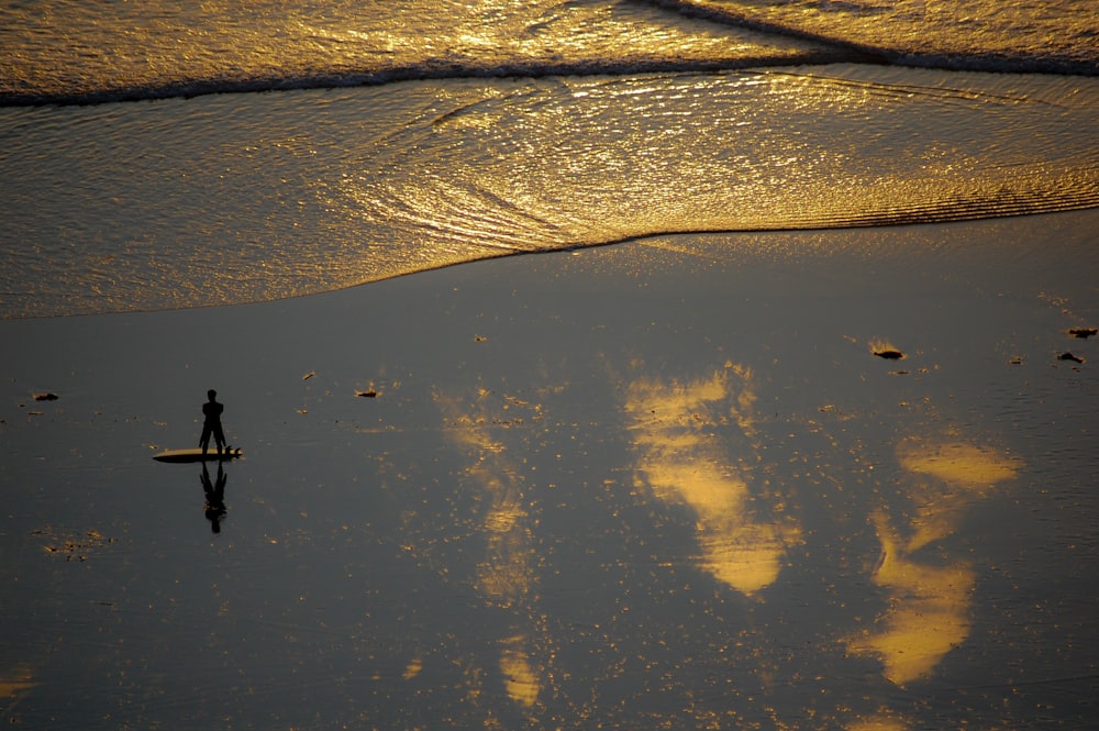 a person standing on a surfboard in the water