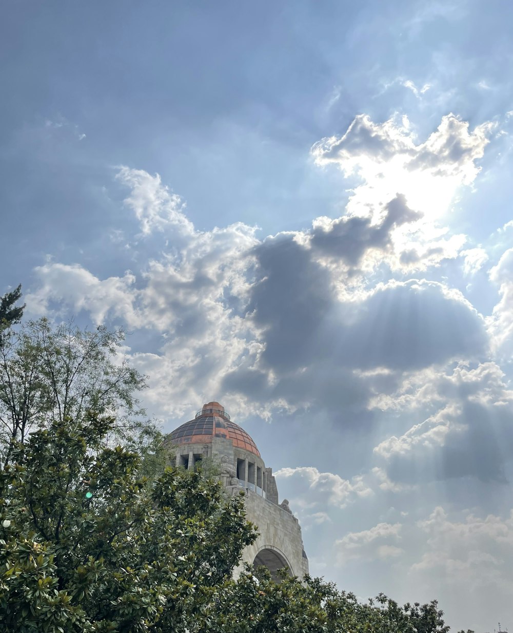 the sun shines through the clouds above a building