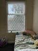 A cozy dorm room corner featuring essential supplies like bedding, lamps, and storage boxes.