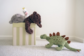 two stuffed animals sitting on top of a box
