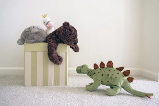 two stuffed animals sitting on top of a box