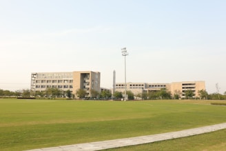 a grassy field with a building in the background