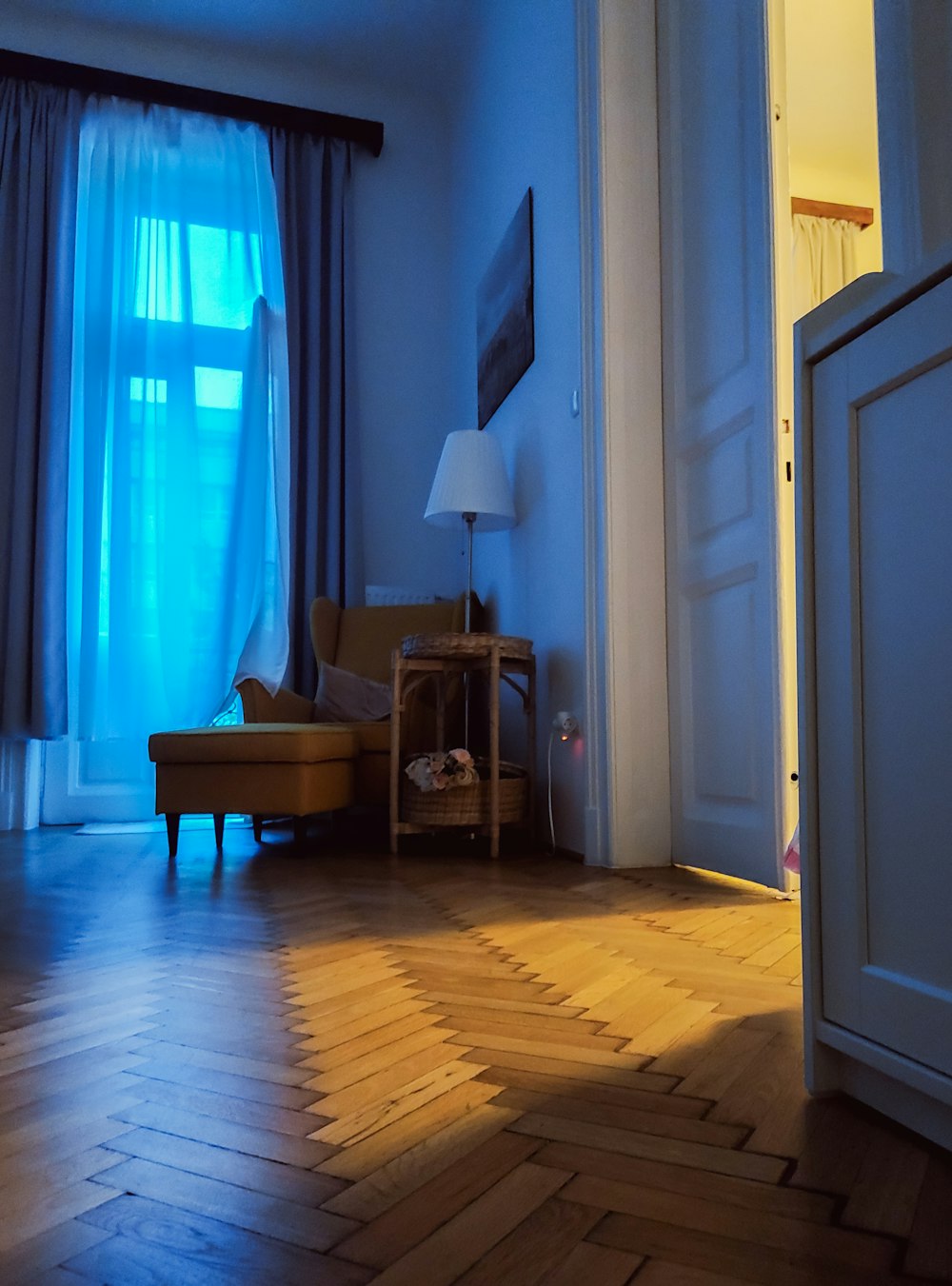 a living room with a chair and a lamp