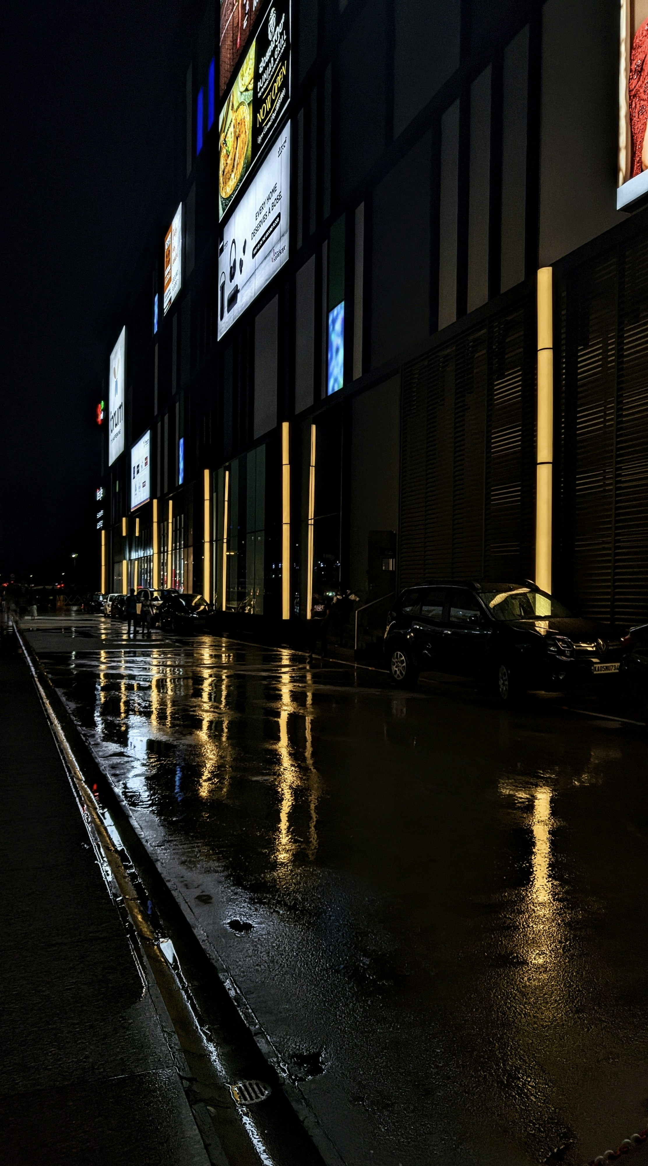 a city street at night with cars parked on the side of the street