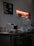 A modern coffee bar setup with various equipment including a coffee machine, kettle, and glass jars. A menu board on the wall lists different coffee options such as espresso, americano, and mocha. Shelving holds additional items like a speaker and cups.