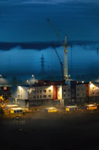 A sleek, modern construction site at dusk with subtle golden lighting highlighting structural details.