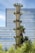 a tall tower of plants in front of a building
